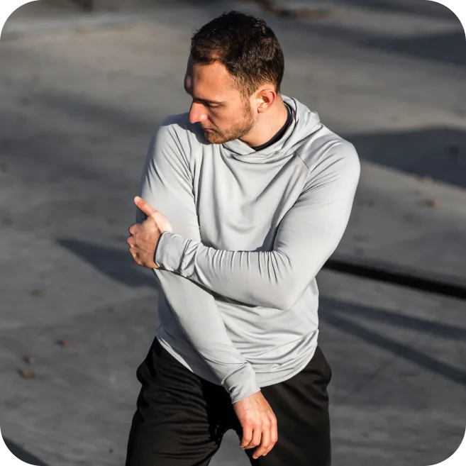 Man holding his elbow due to joint pain from possible cartilage damage or bone injury