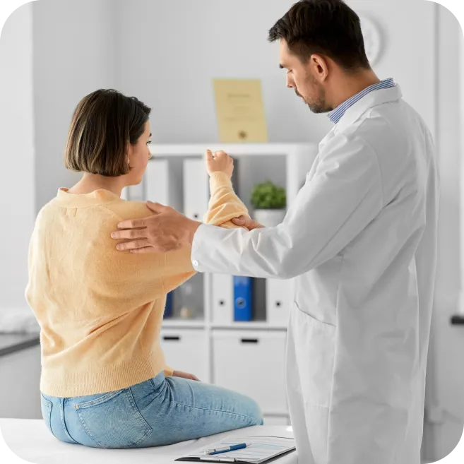 doctor assessing woman's shoulder mobility and pain caused by impingement or bursitis