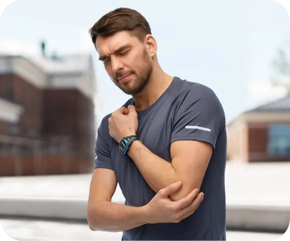 Man holding his elbow in pain after injury, representing symptoms of an olecranon fracture such as swelling, tenderness, and difficulty straightening the arm