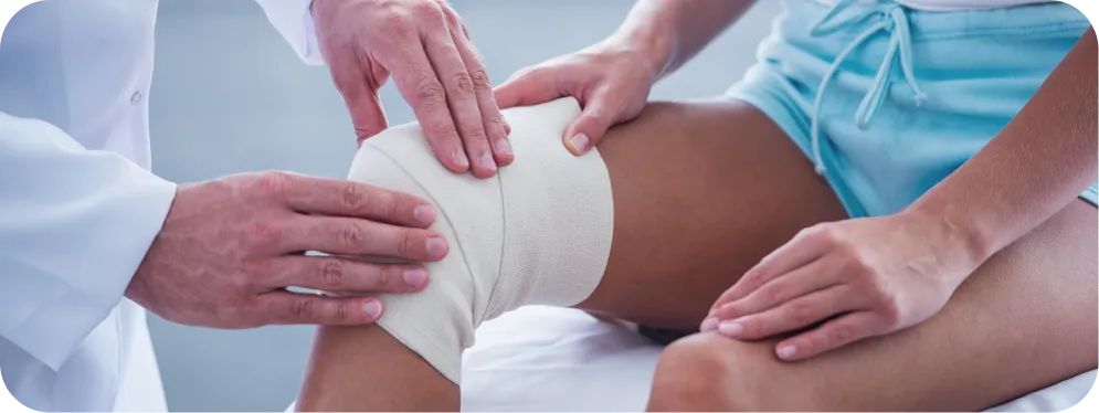 Doctor examining and bandaging a patient’s knee after meniscus repair surgery to support healing and joint stability