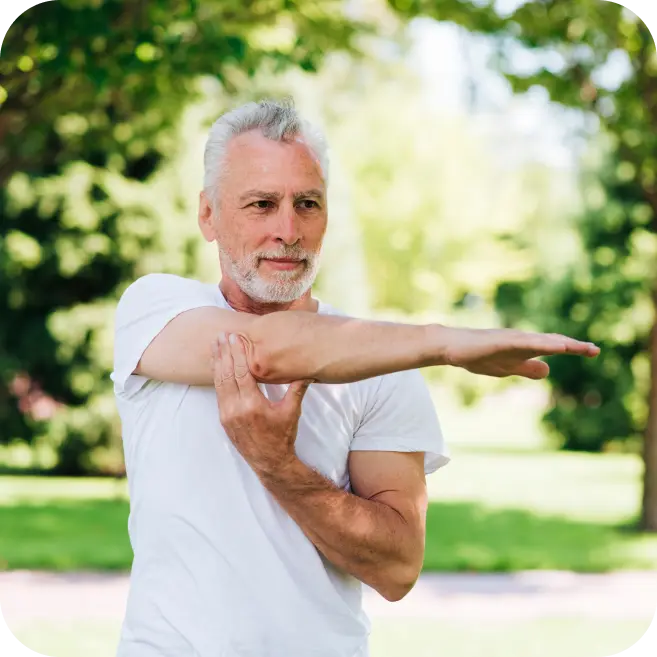 older man stretching shoulder to maintain mobility and prevent early degenerative arthritis