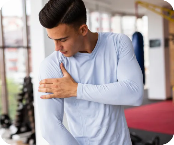 Man clutching his shoulder in pain, showing symptoms of a pectoralis tendon rupture