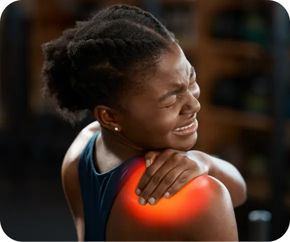 Woman holding her painful shoulder with visible discomfort, illustrating common symptoms of a SLAP lesion (superior labrum tear)