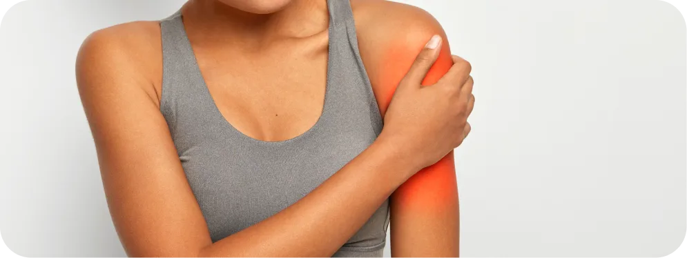 Woman holding shoulder with visible pain, showing common symptoms of a biceps tendon partial tear or bicipital labral complex injury.