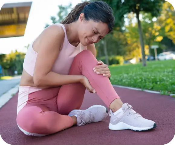 Woman holding her knee in pain after exercise, showing symptoms of a subchondral femur or tibial fracture before Subchondroplasty treatment