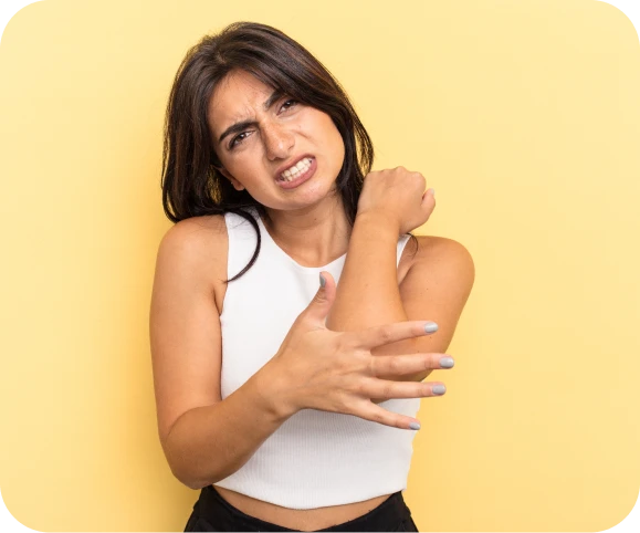 Woman holding inner elbow due to pain, illustrating symptoms of chronic medial epicondylitis (golfer’s elbow) and tendon injury